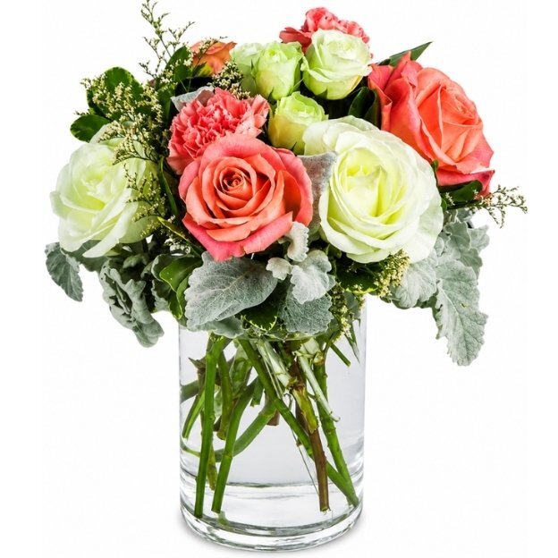 Elegant mixed rose arrangement in a glass vase with coral, peach, and green blooms.