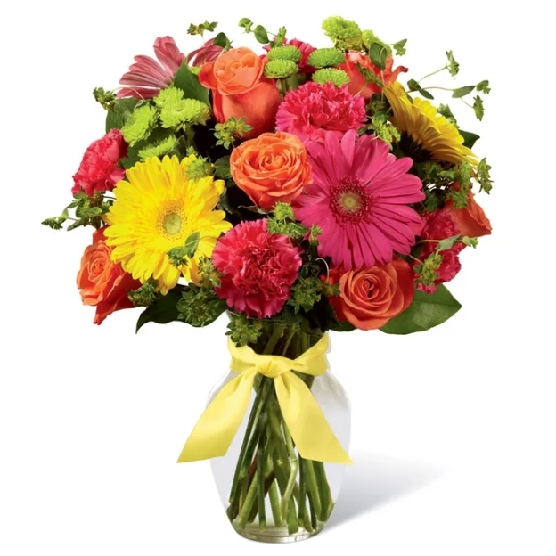 Vibrant floral arrangement featuring pink, orange, and yellow flowers in a clear glass vase with a decorative ribbon.