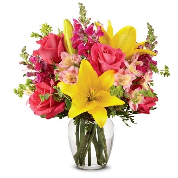 Bright flower arrangement with yellow lilies, pink roses, snapdragons, and soft peach accent flowers.
