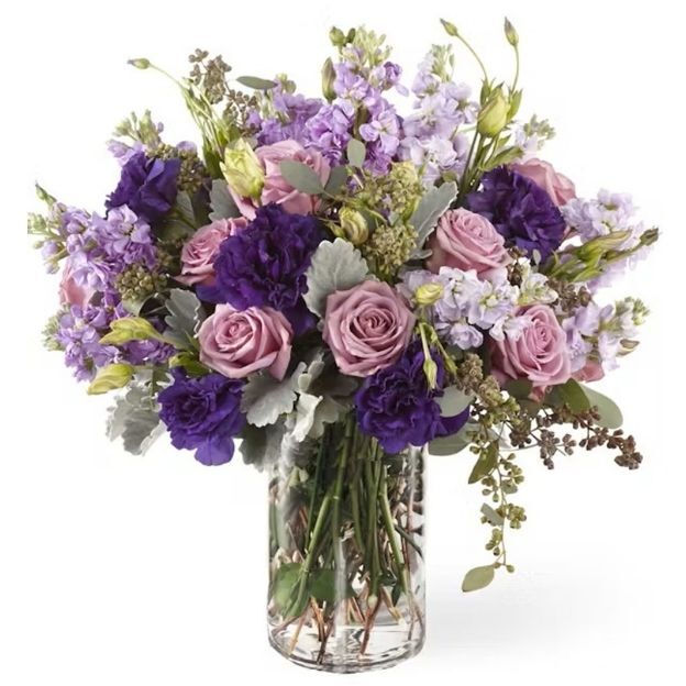 Lush vase design in soft lavender and rich purple with roses, lisianthus, fragrant garden stock, dusty miller, and seeded eucalyptus.