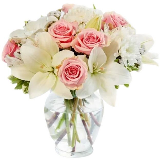 Soft and elegant arrangement with white lilies, light pink roses, white Peruvian lilies, and soft white accents.